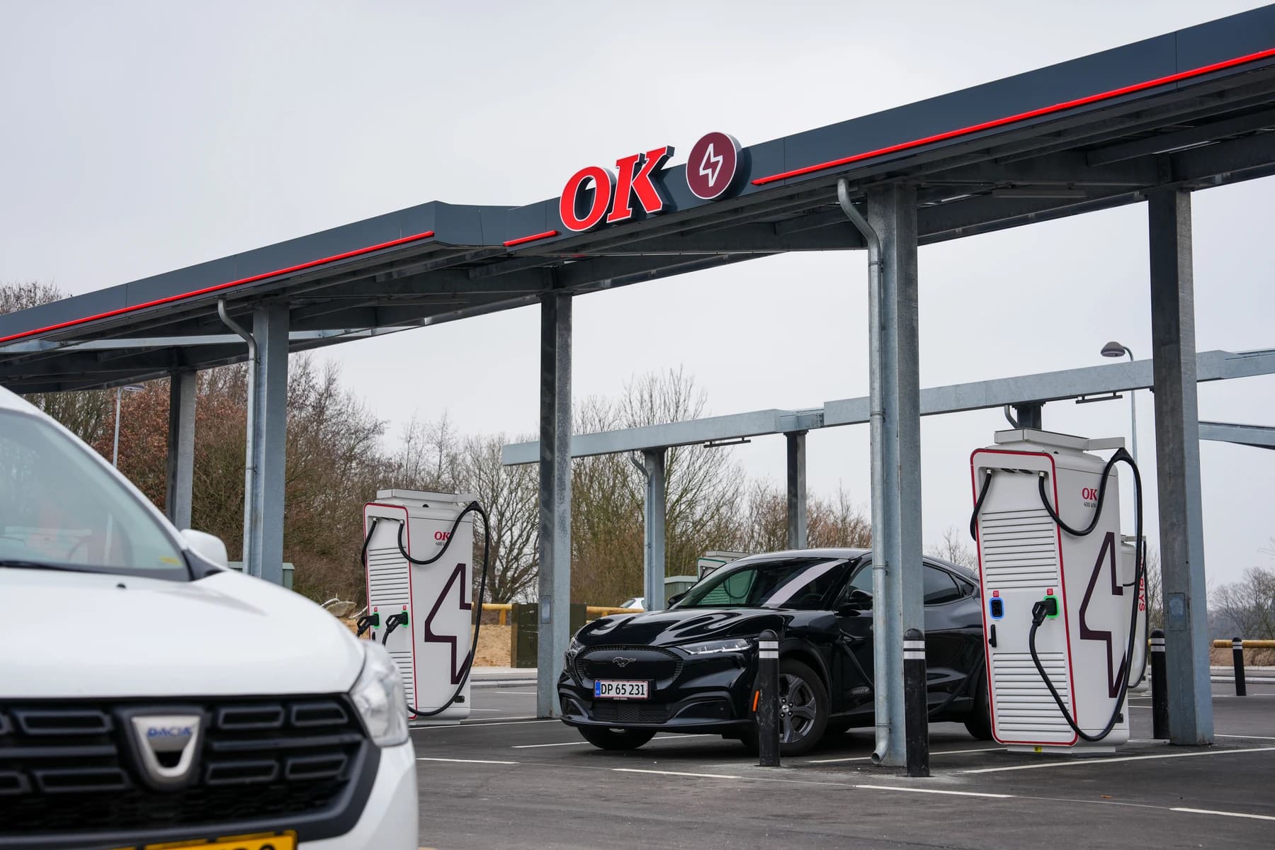 Electric cars charging beneath the canopy at an OK charging park.